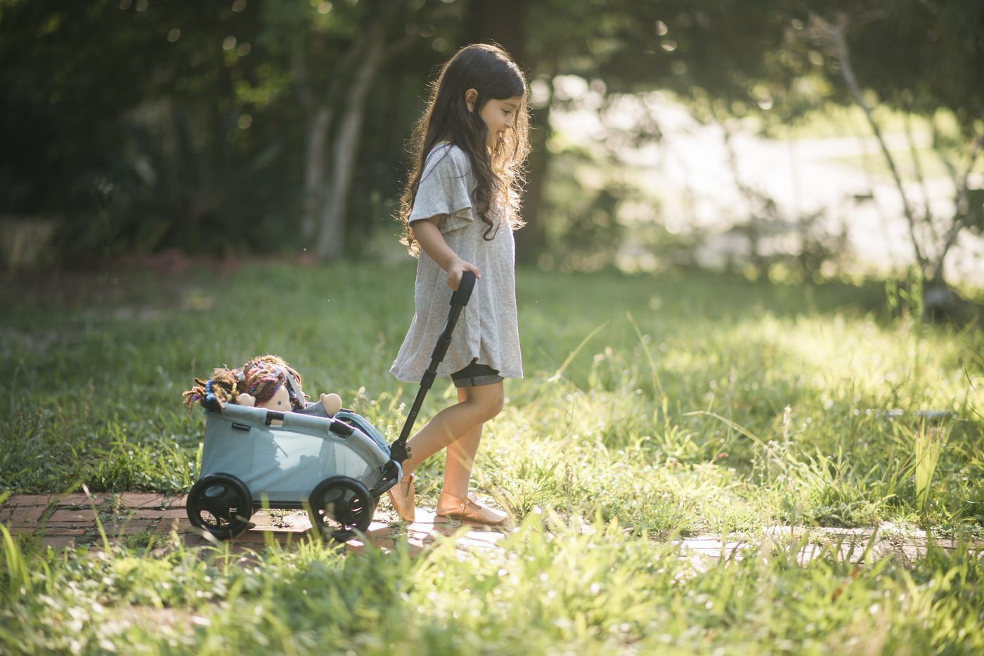 A girl in golden-hour light with a mint wagon
